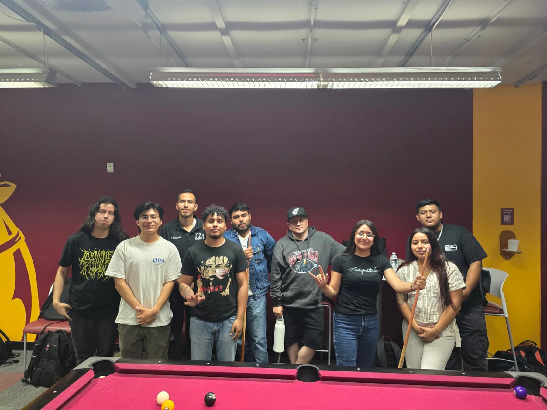 LSBA members gathered around the pool table in the LSBA Lounge at a social night.