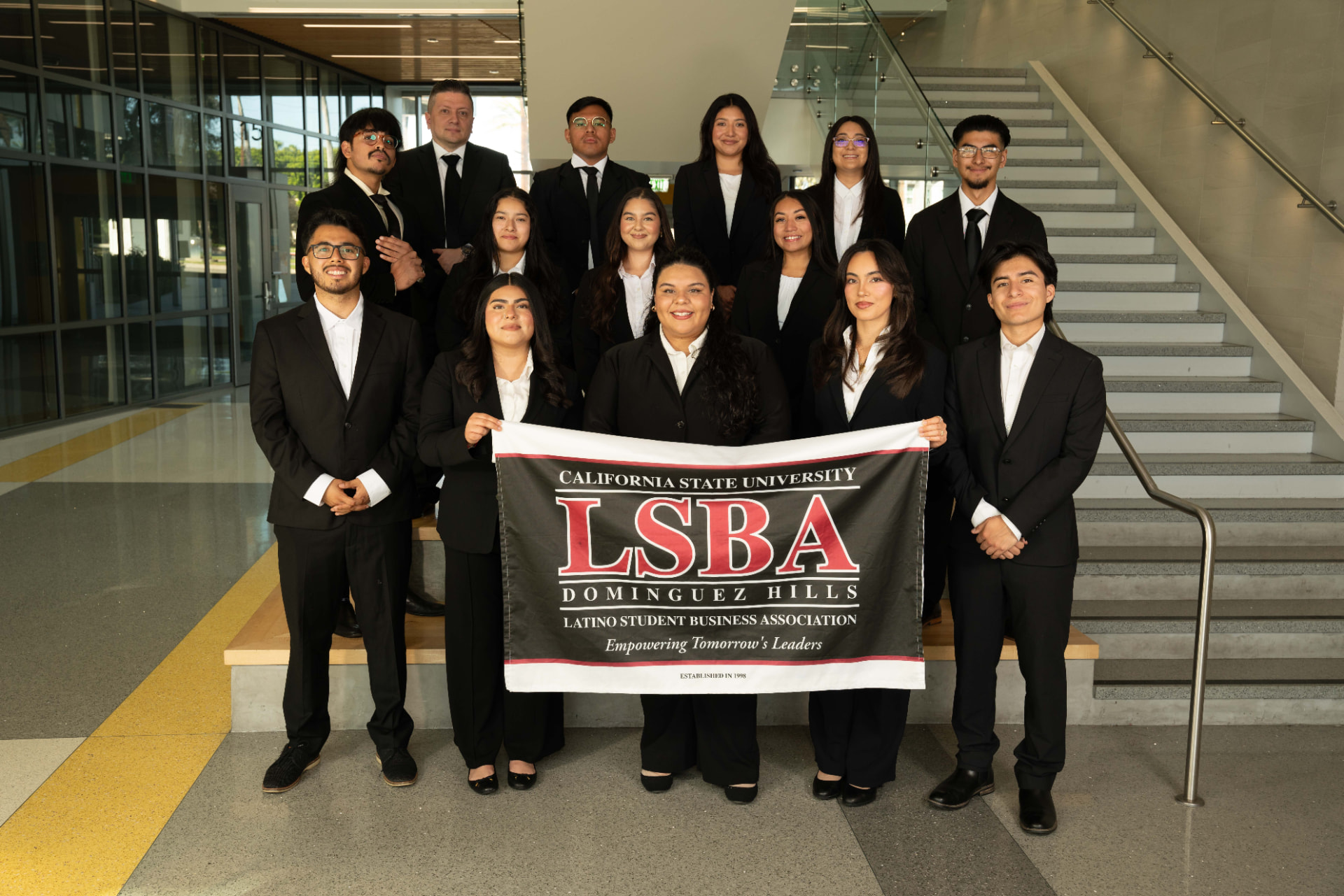 LSBA board members in business attire holding the California State University Dominguez Hills Latino Student Business Association banner